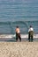 Sennon Cove Cornwall England. Two men casting a fishing net from the beach