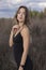 Sensitive attractive slim brunette in skinny fitting black dress in the field. autumn, yellow leaves, blue sky