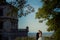 Sensitive outdoor portrait of the beautiful young newlywed couple tenderly hugging at he background of the old castle