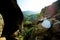 Sensitive outdoor wedding portrait. The bride is hugging the groom back while sitting on the rock at the background of