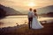 Sensitive wedding back shot. Peaceful beautiful newlyweds are hugging and looki at each other on the river bank during