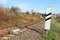 Sensor signaling the passage of the train on the railway track to activate the alarm at a road crossing. Mound of coarse gravel