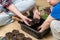 Sensory activities for child - young mother and son playing with dirt prepared for seeds. At home gardening and learning botany