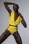 Sensual african american woman in yellow body and leather garters
