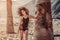 Sensual afro woman posing with palm tree on the sandy beach in Tenerife