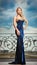 Sensual blonde with blue dress on ledge