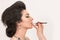 Sensual brunette woman retro styled during makeup lips retouch o