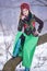 Sensual Caucasian Girl in Fashionable Green Dress and Kokoshnik with Flowery Pattern and Beads. Sitting on Tree in Winter Snowy