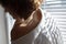 Sensual close up portrait of beautiful young lady relaxing at the window. female shoulder close up. hard shadows