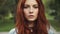 Sensual closeup portrait of beautiful red-haired girl in a summer Park. 20s