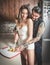 Sensual couple casual dressed cutting a lemon in the kitchen