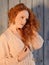 Sensual female model Ivory Flame in pensive pose with long cascading red hair