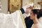 Sensual happy bride and groom wearing gold crowns during wedding ceremony in christian church, coronation ritual indoors face