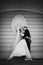 Sensual, happy newlywed valentynes hugging, wall with bust background b&w