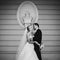 Sensual, happy newlywed valentynes hugging, wall with bust background b&w