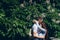 The sensual hugging couple in love near the green blooming tree in Budapest, Hungary. The handsome man is tenderly