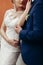 Sensual newlywed couple posing near wall outdoors in the city, wedding celebration, happy bride and groom holding hands portrait,