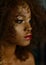 Sensual portrait of magic surreal golden african american female model with bright glitter makeup, glossy golden