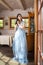 Sensual Relaxed Caucasian Brunette Female in Blue Wedding Dress With Tiara. Posing Indoors in Farm House