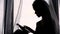 Sensual Silhouette Portrait of a Young Woman with Tablet