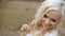 Sensual stunning young blonde bride charmingly smiling. Outdoor blurred field background