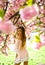 Sensual woman at blossoming sakura flower in spring. Sakura flower beauty in nature. Skincare and summer concept. Womens