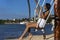 Sensual woman relaxing on a caribbean swing, where she enjoys an excellent panoramic view of the sea of the Mayan Riviera.