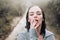 Sensual woman standing under the rain screaming and enjoying. Portrait of young beautiful woman standing on the street