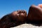 Sensual young african woman lying on rock outdoors