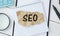 Seo Career. Opened Notebook With Seo-Optimization Scheme Lying Over Brown Office Table Background. Search Engine Optimization For