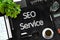 SEO Service on Black Chalkboard. 3D Rendering.