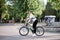 Sep 7, 2019-Ternopil/Ukraine:Young brunette woman, wearing black leggings and white pullover, riding a bike in city town park with