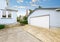 Separate garage with blue and white trim and driveway.