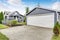 Separate garage with siding trim, concrete driveway and white door