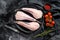 Separate raw fish monkfish. Black background. Top view
