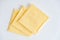 Separately packed cheese slices on a white wooden table background