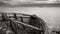 Sepia colored view from a fishing boat shipwreck on shore over the vast Atlantic ocean under a dramatic sky, West Fjords, Iceland