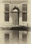 Sepia image of an old building along a canal in venice with shutters and doorway reflected in the water in bright sunlight and s