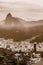 Sepia toned View of city Rio de Janeiro with Favelas in the hills with misty statue on mountain