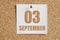 September 03. 03th day of the month, calendar date.White calendar sheet attached to brown cork board.Autumn month, day of the year