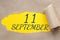 september 11. 11th day of the month, calendar date.Hole in paper with edges torn off. Yellow background is visible