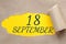 september 18. 18th day of the month, calendar date.Hole in paper with edges torn off. Yellow background is visible