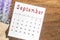 September 2022 calendar with flower on wooden background