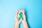 September Ovarian cancer Awareness month, Woman holding teal Ribbon color on blue background for supporting people living, and