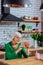 Septuagenarian dame sitting at kitchen and blandly palming photo frame