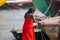 Sequence: lower chaste woman in a bright red sari washing a red vest in the river Ganges, in Varanasi, India