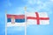 Serbia and England two flags on flagpoles and blue sky