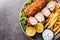 Serbian Breaded Rolled Cutlet Karageorge Schnitzel with french fries and tartar sauce close-up in a plate. Horizontal top view