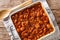 Serbian food: prebranac baked beans with onion close-up in baking dish. horizontal top view from above