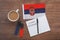 Serbian national flag, cup of coffee, notebook with the inscription learn serbian, two markers on the desktop